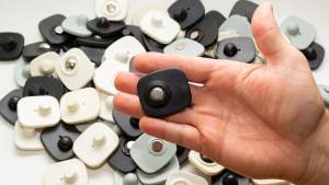 Hand holding an RFID tag with multiple tags in the background